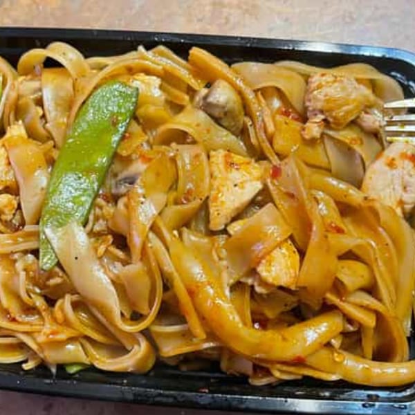 Jenni's Noodle House Vietnamese dish with wide noodles, chicken, mushrooms, and a snow pea pod.