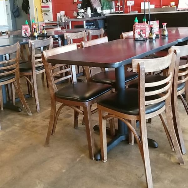 Interior of Jenni's Noodle House with empty tables and chairs, and condiments on tables.