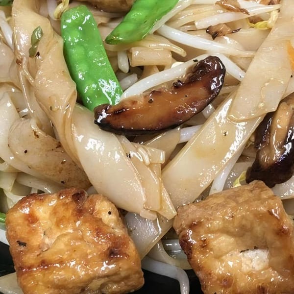 Close-up of Vietnamese noodles with tofu, mushrooms, bean sprouts, and green beans.